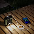 Outdoor Wooden Table Setup With Smartphone Charging And Portable Digital Speaker