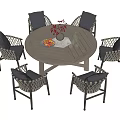 Outdoor Wicker Dining Set with Round Table Gray Cushioned Chairs Flower Vase and Fruit Platter