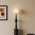 Black Floor Lamp With White Spherical Shade And Black Framed Colorful Circle Wall Art