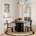 Round Wooden Table And Two Black Chairs with White Cushions and Flower Vase by Window