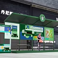 Starbucks Themed Green Bus Shelter with Advertisement Billboards and Woman Holding Bag