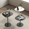 Black and white round coffee tables with magazines plants and cups in modern living room