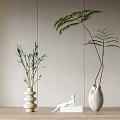 White and Beige Stacked Vases with Bamboo and Long Leaved Plants on Wooden Countertop