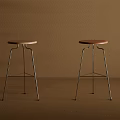 Two Modern Bar Stools With Brown And Beige Seats And Metal Legs Against Brown Wall