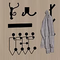 Various Metal Wall Hooks On Wooden Surface With Hanging Striped Coat