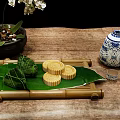 Traditional Chinese Zongzi and Mooncakes on Reed Leaves with Bamboo Tray and Porcelain Vase