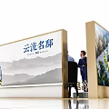Modern Exhibition Booth Tables and Chairs with People Interacting and Display Backdrops
