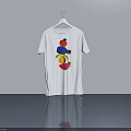 White T Shirt With Colorful Pattern Hanging On Hanger Against Gray Wall