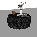 Black Round Coffee Table With Textured Surface And Vase Dried Flowers Books Small Pottery Jar