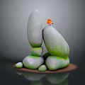 Small Orange Bird Perched On Artfully Stacked Greenish Stones Against Dark Background
