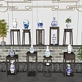 Traditional Blue and White Ceramic Vessels on Wooden Stands with Brick Wall and Green Plants