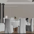 Modern Round Dining Table Set With White Tablecloth Flower Vase And White Surrounding Chairs
