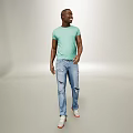 Man Standing in Light Green T-shirt and Distressed Jeans with White Shoes on Gray Background