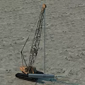 Tracked Crane Functional Vehicle With Extended Boom Performing Lifting Operation At Sandy Site