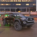 Black Toyota Pickup Truck With Off Road Wheels On Urban Street