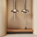 Two Silver Kitchen Range Hoods Mounted on Wooden Walls with Shelf and Dried Branch Decorations
