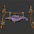 Purple and pink fish hanging on wooden structure made with sticks and ropes