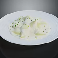 Creamy White Ravioli in Rich Sauce Garnished with Fresh Green Herbs on White Plate