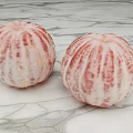 Two Fresh Peeled Pomelos With Striated Texture on Marble Surface