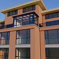 Glass Sunroom Attached To Red Brick Building With Black Frame And Glass Windows