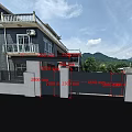 Modern Black Slatted Entrance Gate With Gray Pillars And Mountain View Greenery