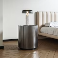 Modern Bedside Table with Brushed Metal Finish and Table Lamp Next to Upholstered Bed
