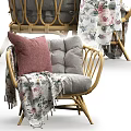 Stylish Wicker Outdoor Chair With Pink Cushion And Floral Blanket For Patio Use
