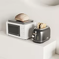 Modern Kitchen Appliances On White Counter With White Microwave Black Toaster And Bread