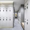 Neatly Arranged Numbered White Lockers Interior With Corridor Walls And Gray Floor
