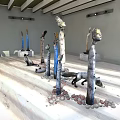 Indoor Sculpture Exhibition With Humanoid Animal Figures Pebbles And Wooden Ceiling