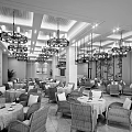 Inviting Café Interior With Wicker Chairs Green Tablecloths Chandeliers And Decorative Paintings