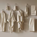 Soft Beige Towels and Bathrobes Hanging on Wall Hooks and Racks