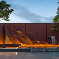 Modern Geometric Building Exterior Wall With Brown Textured Surface And Fountain Feature Surrounded By Trees