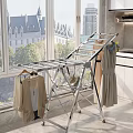 Silver Metal Clothes Drying Rack Foldable Design Near Window With Dresses And Cardigans