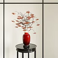 Red Vase With Branches Bearing Red Berries On Black Stand Against Light Wall