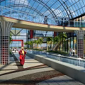 Spacious Shopping Mall Lobby Featuring Glass Dome Walkway Palm Trees Fountains And Dior Storefronts