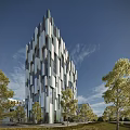 Modern Office Building Exterior With Geometric Glass Facade And Surrounding Trees Under Blue Sky