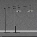 Two Modern Floor Lamps With Sleek Black Poles And Round Shades Against Grey Wall Background
