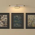 Three Framed Artworks On Beige Wall With Above Wall Light Fixture