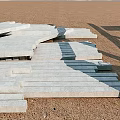 Sturdy Swing Door Construction Using Stacked Gray Stone Slabs On Sandy Ground