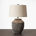Beige Linen Lampshade Table Lamp With Textured Ceramic Base On Dark Wooden Tabletop