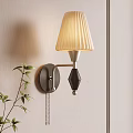 Modern Wall Lamp With Pleated Beige Shade And Metallic Body Design Near Green Plant