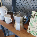 Modern Cafe Interior With Coffee Sign Metal Grid Wall Green Plants Wooden Bar And Black Stools