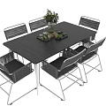 Modern Outdoor Table with Six Wicker Chairs and Vase of Green Plants
