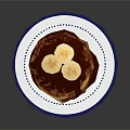 Stacked Pancakes Topped With Banana Slices And Chocolate Sauce On Blue White Plate