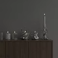 Minimalist Decorative Ornament Set on Wooden Cabinet Featuring Lit Candles and Unique Designs