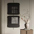 Black Framed Wall Art With Vase And Twigs On Small Cabinet With Books