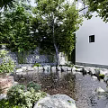 Tranquil Garden Landscape With Pond Stones Lush Trees Brick Wall And Stone Pathways
