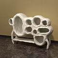 White Abstract Sculpture Carving with Hollow Holes and Textured Surface in Indoor Setting