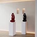 Red And Black Sculptures Displayed On White Pedestals With Wall Lamps